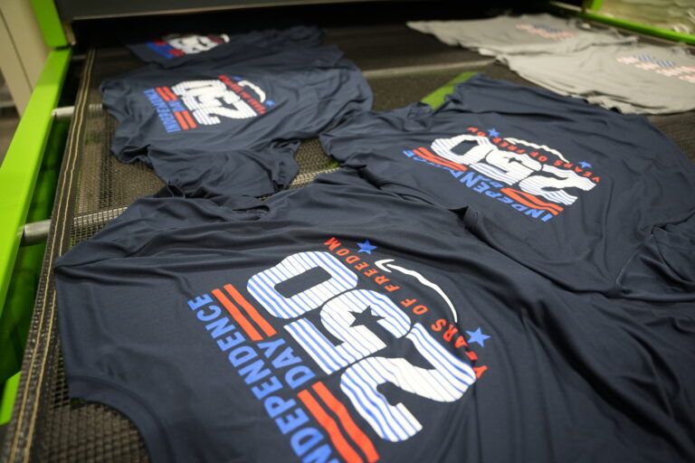 Stacks of screen printed crew t-shirts completed at the Naples shop